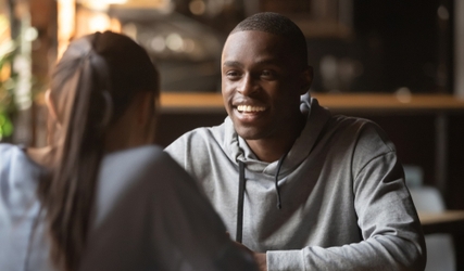 Two people laughing together on a first date in a café