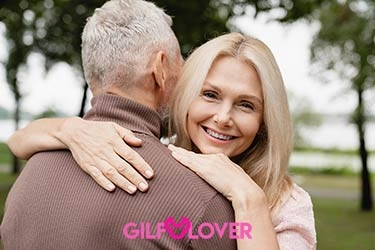 Glamorous older woman cuddling her man while on a romantic date.